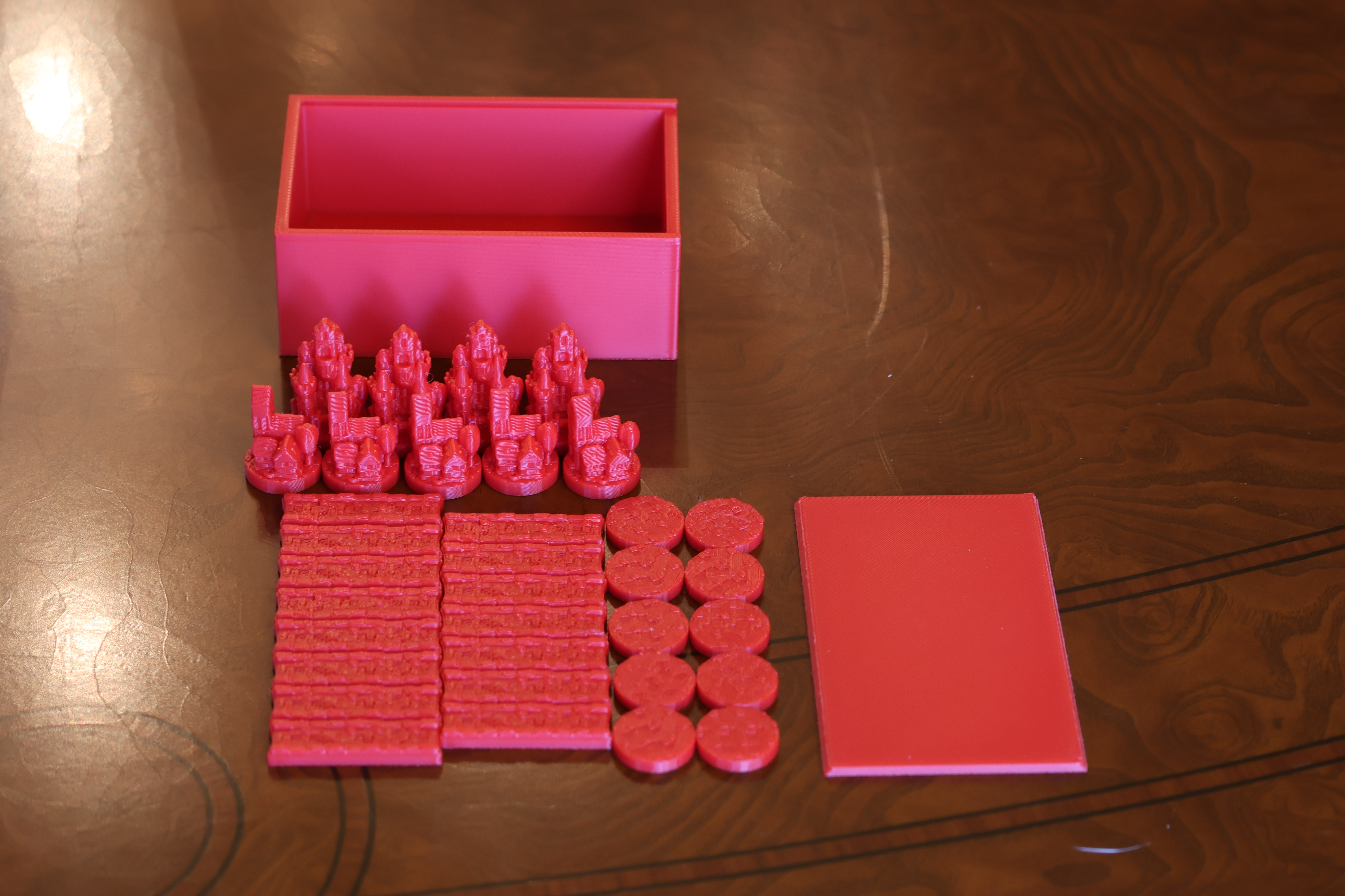 Premium magnetic Catan player pieces in red — settlements, cities, and roads